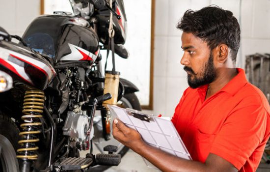 mechanic busy noting down bike repair parts during maintenance repair at grage for customer - concept of professional occupation,repair man and skill labor